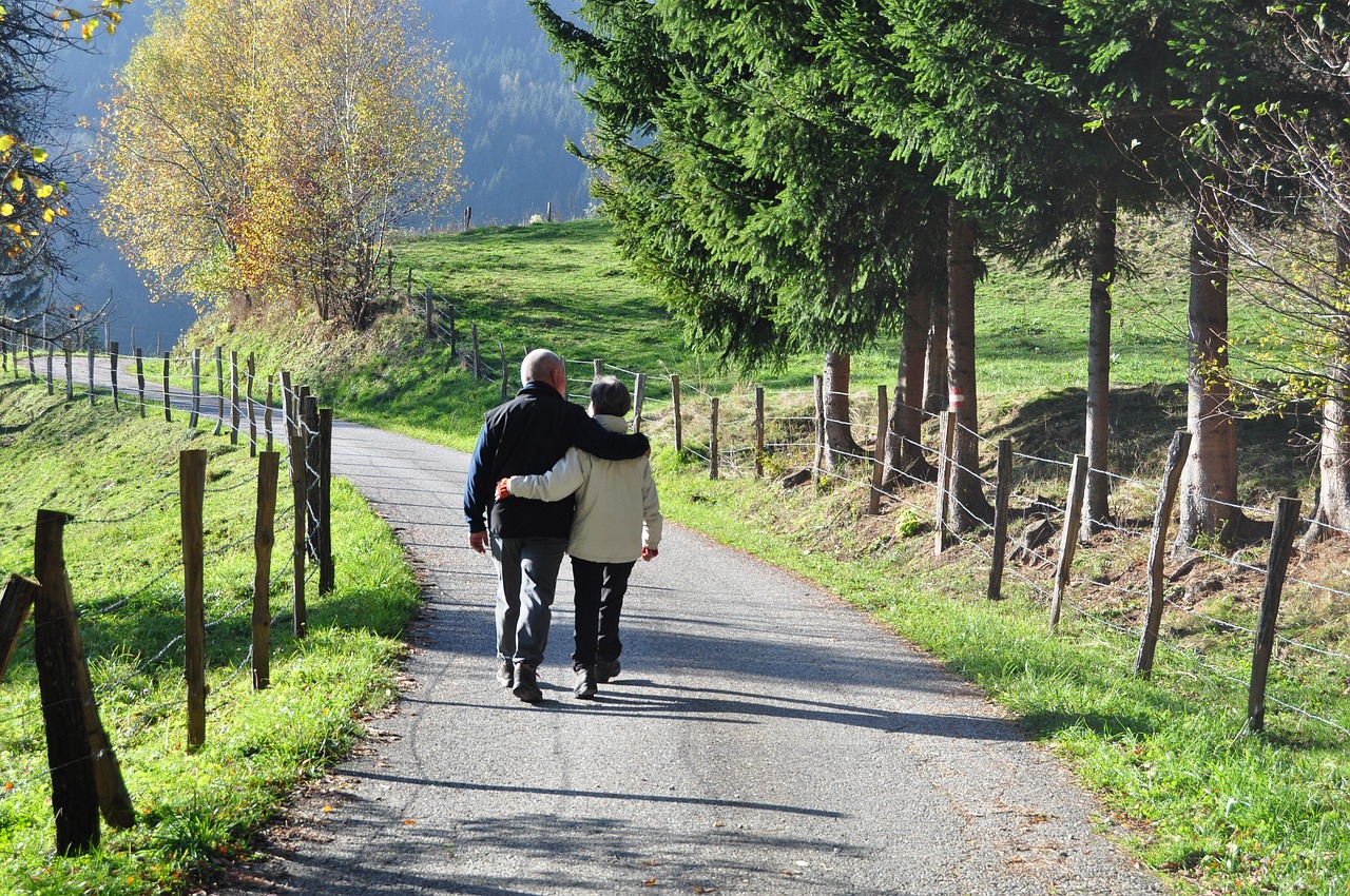 Älteres Paar beim gemeinsamen Spaziergang auf einem Feldweg