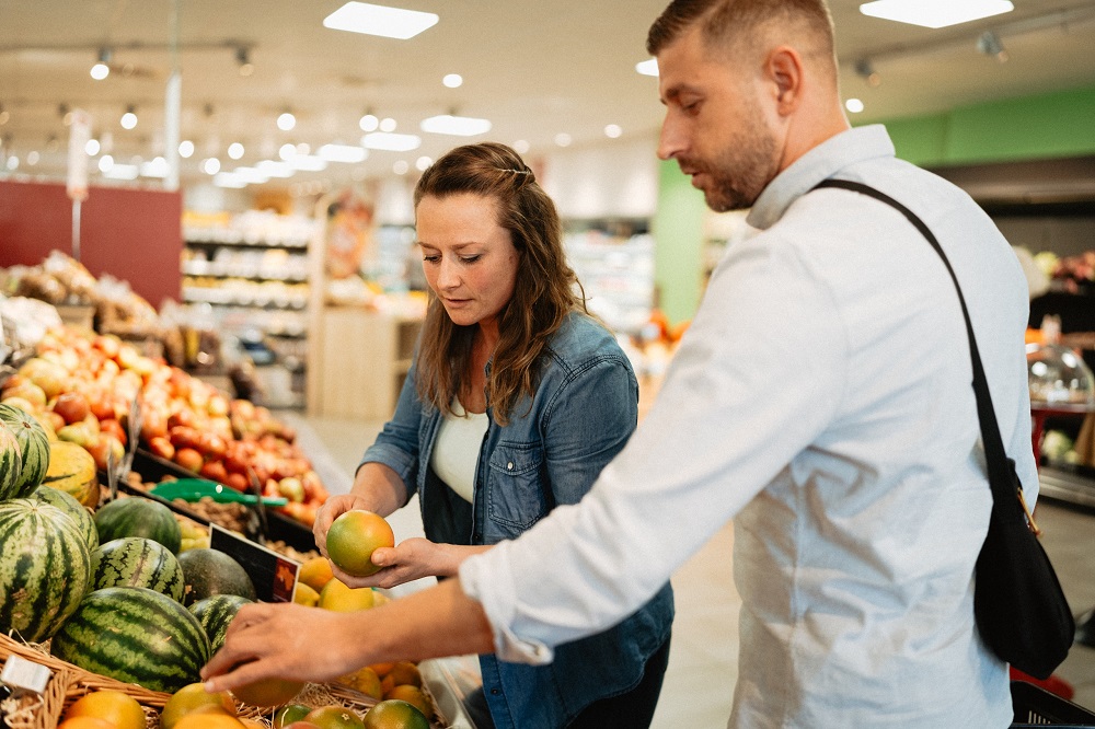 Ernährungsberatung im Supermarkt: Paar wählt gemeinsam Obst aus